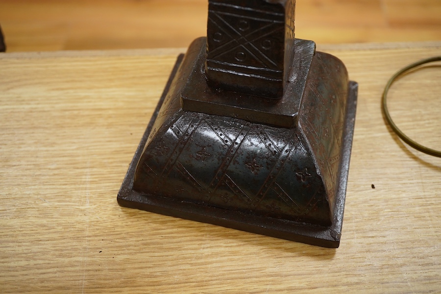 An iron candle stick with incised geometric decoration, 49cm high